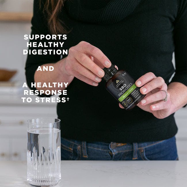 a woman holding a bottle of SBO probiotics mental clarity