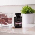 SBO Probiotics Women's Once Daily next to a glass of water
