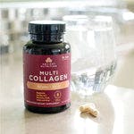 multi collagen capsules beauty sleep bottle next to a glass of water