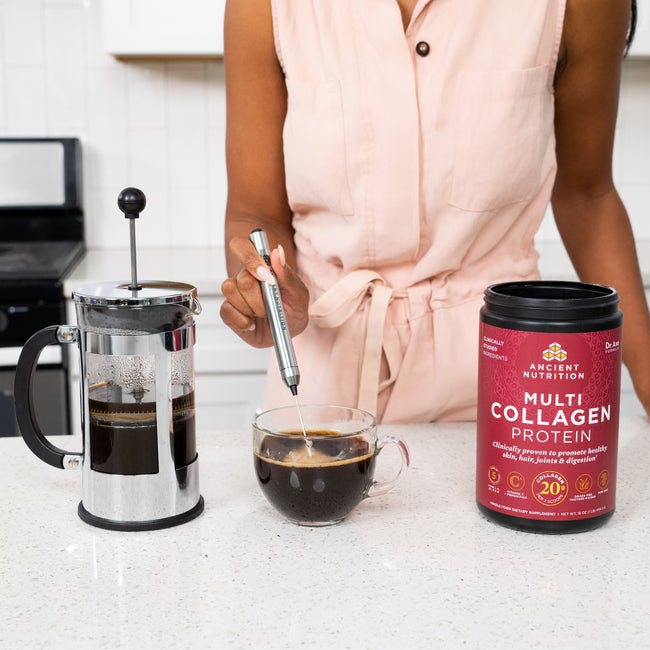 woman mixing multi collagen powder in her coffee