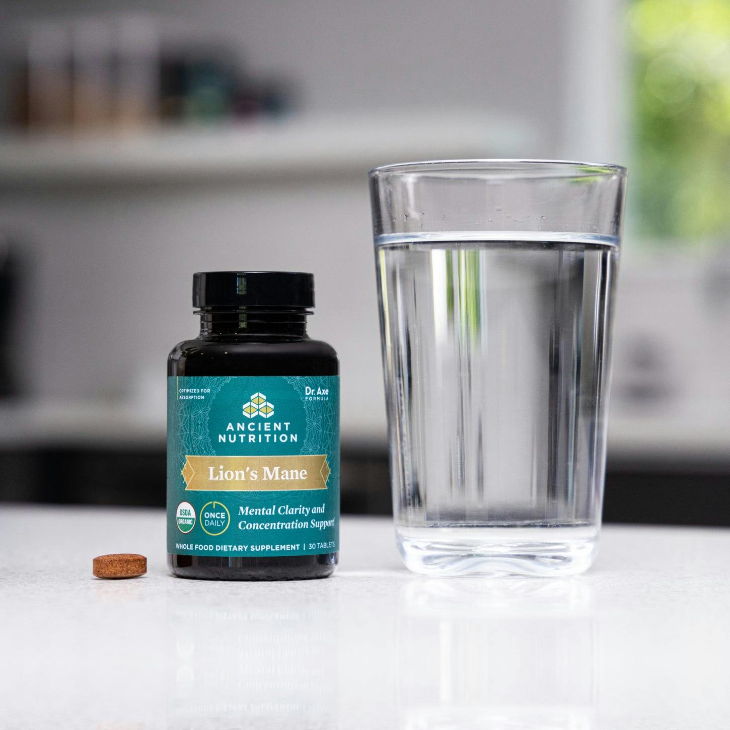 Lion’s Mane Mental Clarity and Concentration Tablets next to a glass of water