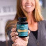 a woman holding a bottle of Lion’s Mane Mental Clarity and Concentration Tablets