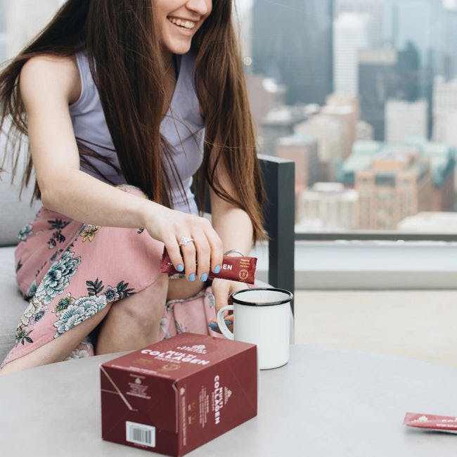 young girl adding multi collagen protein stick pack to coffee cup
