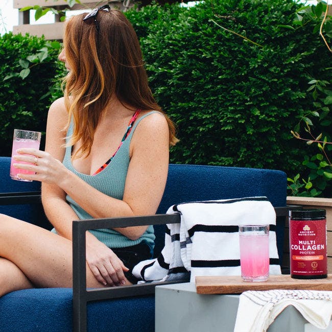 girl outside drinking multi collagen protein strawberry lemonade 