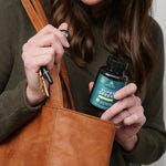a woman taking Organic Super Greens Energizer Tablet out of her purse