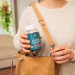 a woman taking Organic Super Greens Gummies Strawberry Watermelon Flavor our of her purse