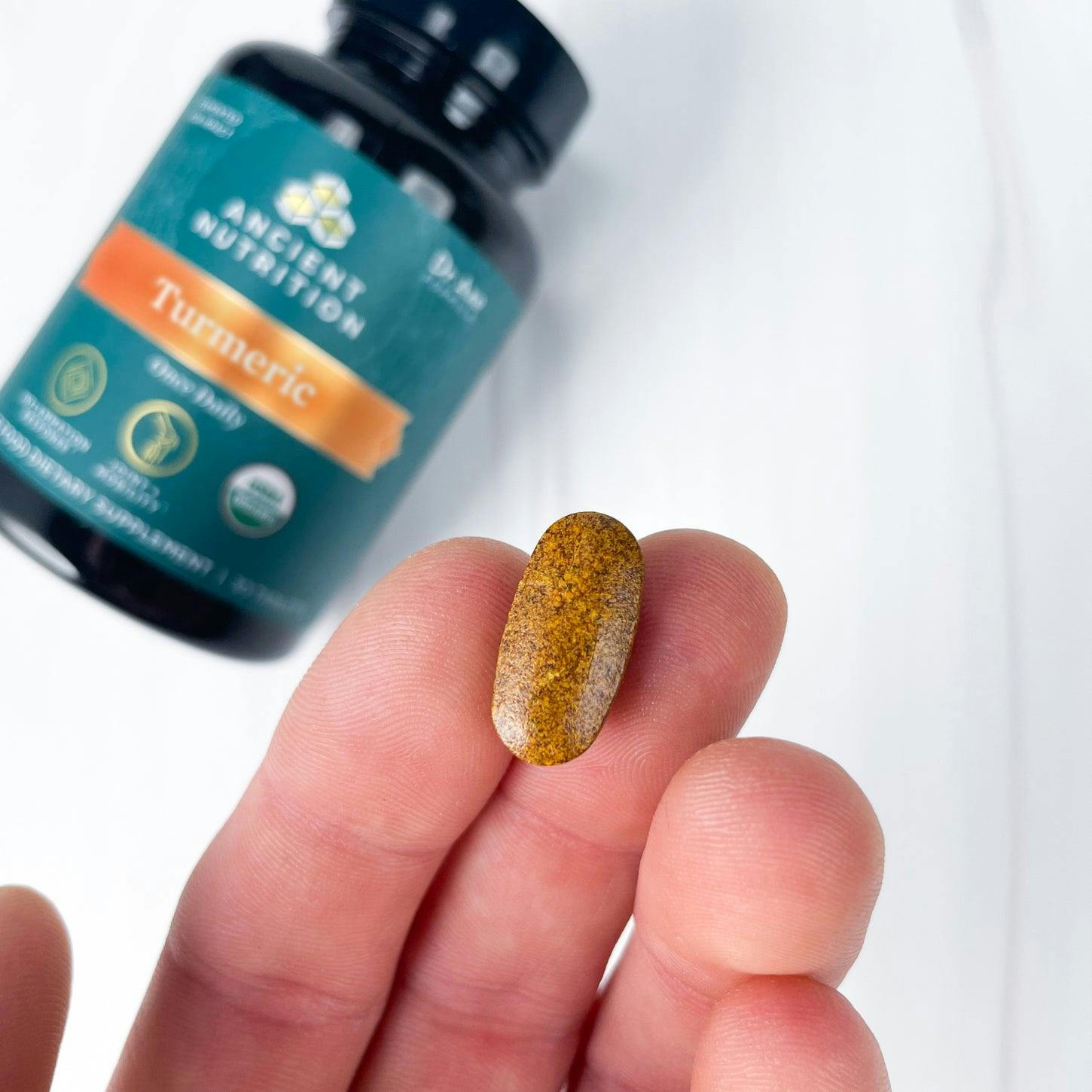 turmeric tablet in palm of hand
