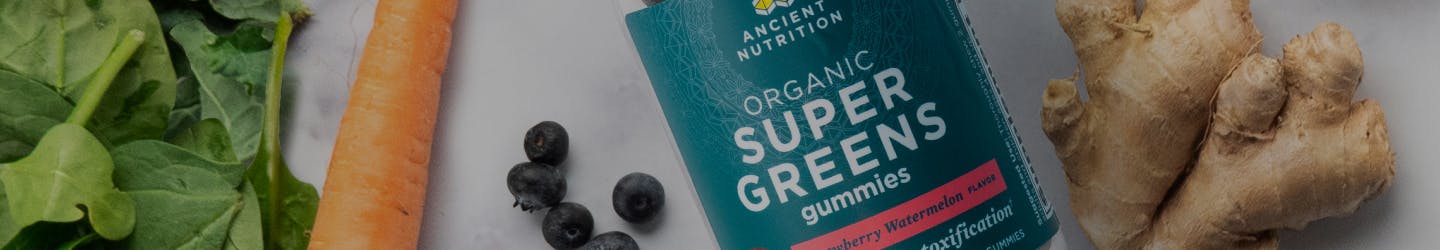 organic supergreens gummies next to fruits and veggies