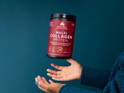 a person tossing a bottle of multi collagen protein in the air