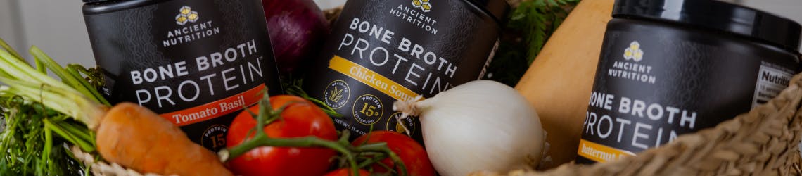 bone broth protein savory bottles behind vegetables