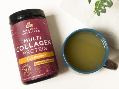 bottle of Multi Collagen Protein Gut Restore next to a mug