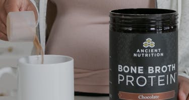 bone broth next to a white cup