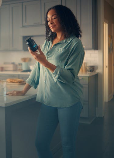 woman looking at SBO probiotics bottle